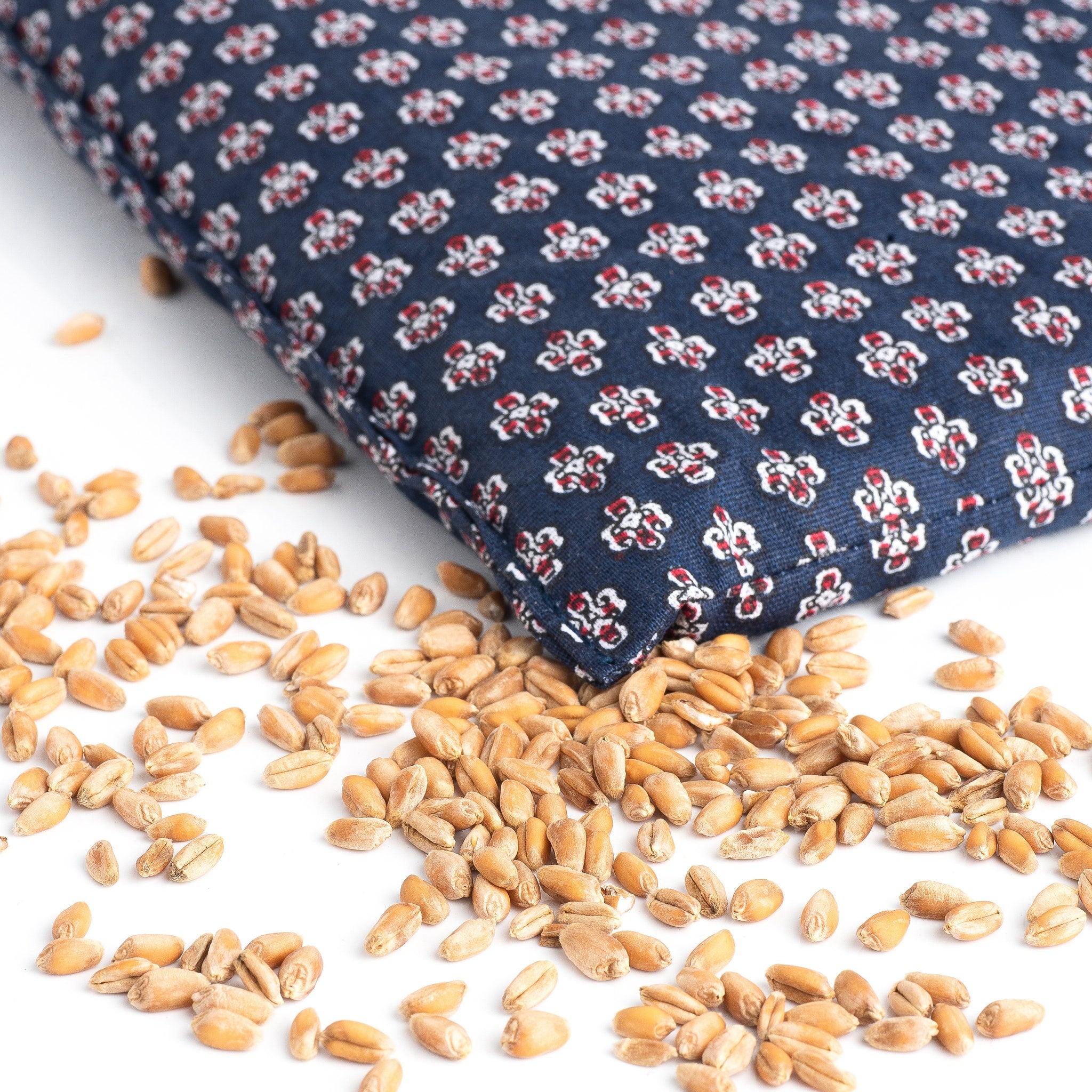 Blue floral patterned fabric with wheat kernels on white surface