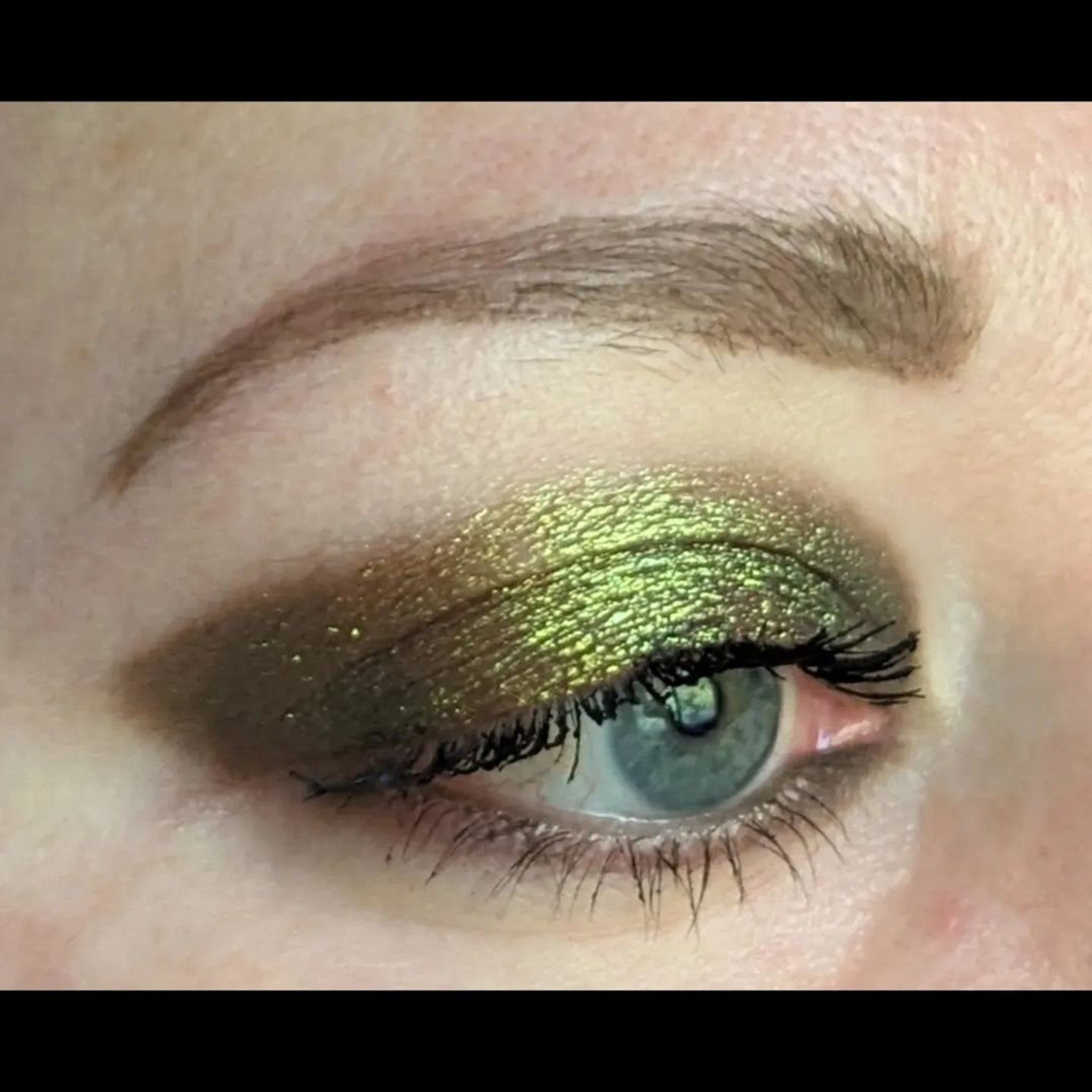 Pressed eyeshadow pan showcasing trichrome chameleon effect shifting between three shimmering vegan shades