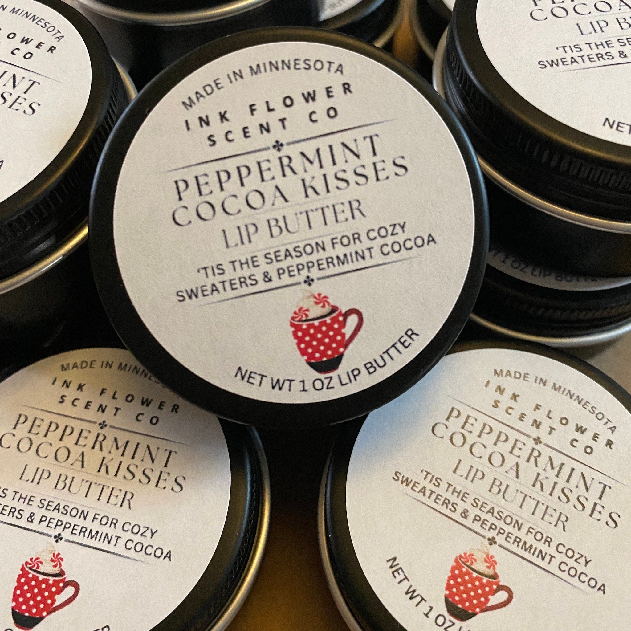 Lip butter tins with black lids, white labels, and Ink Flower Scent Co branding
