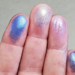 Close-up of duochrome eyeshadows shifting between vibrant hues in a sleek black palette