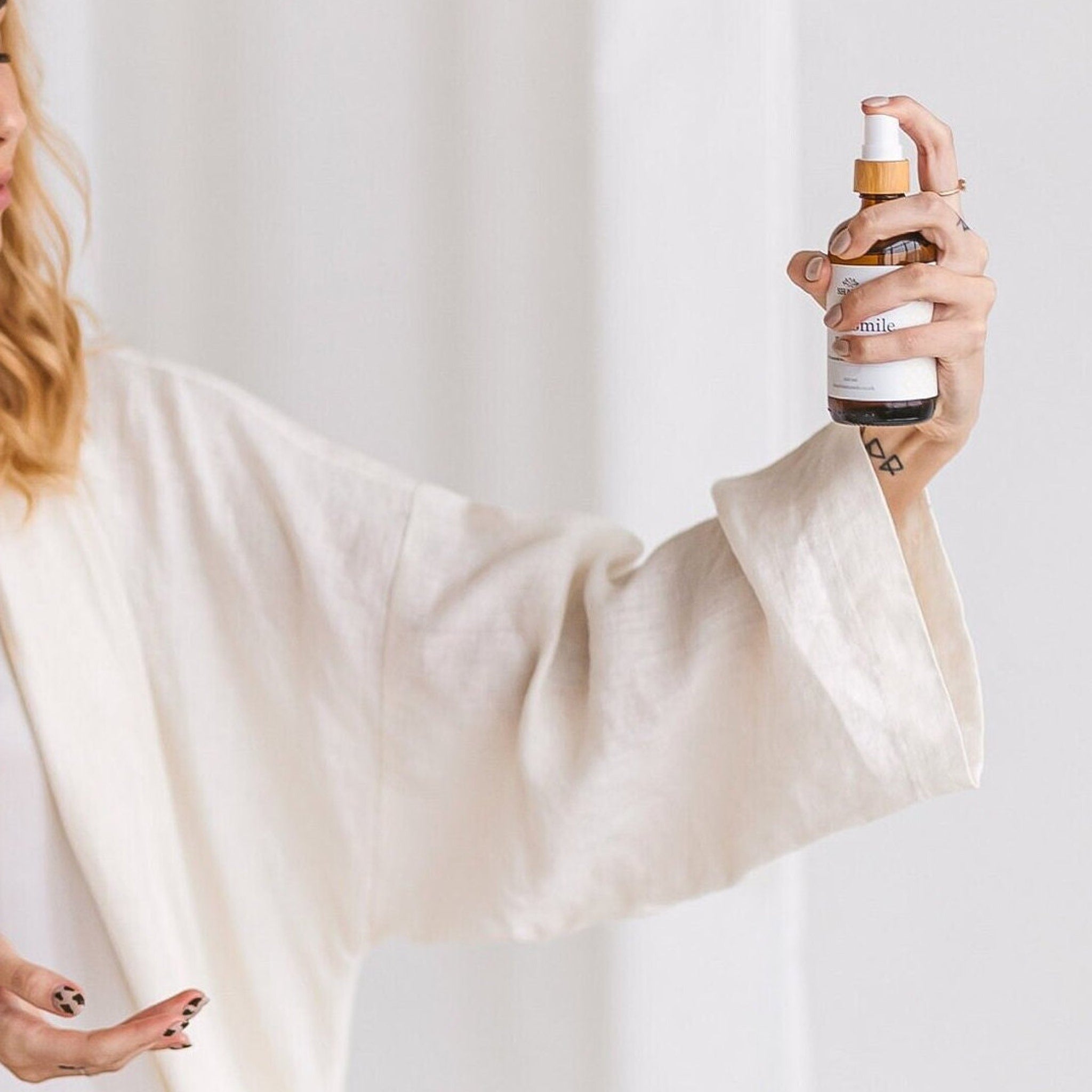 Elegant amber glass spray bottle of rose and lavender hydrosol toner with gold detailing