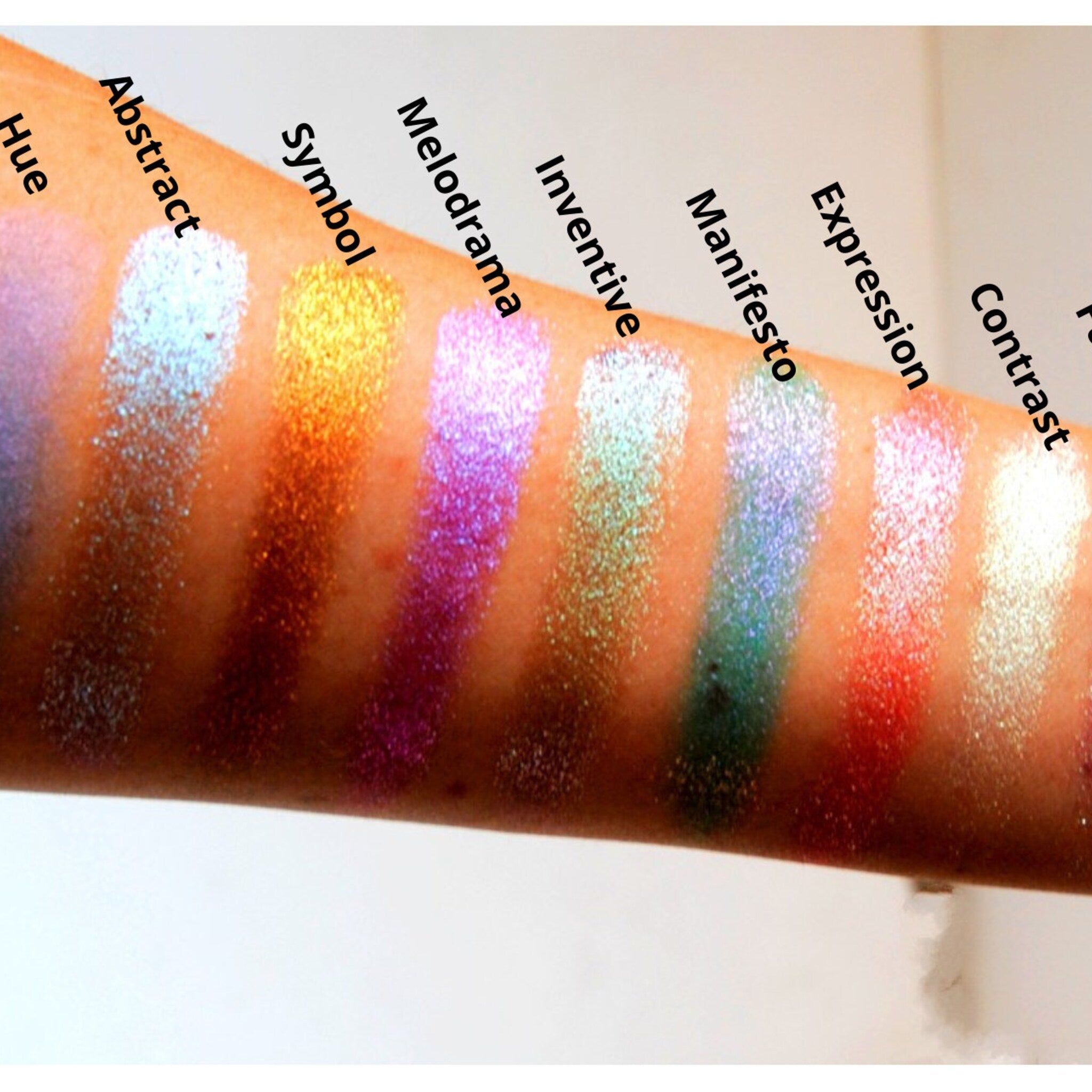 Hand applying teal and silver duochrome eyeshadow with iridescent shift to eyelid