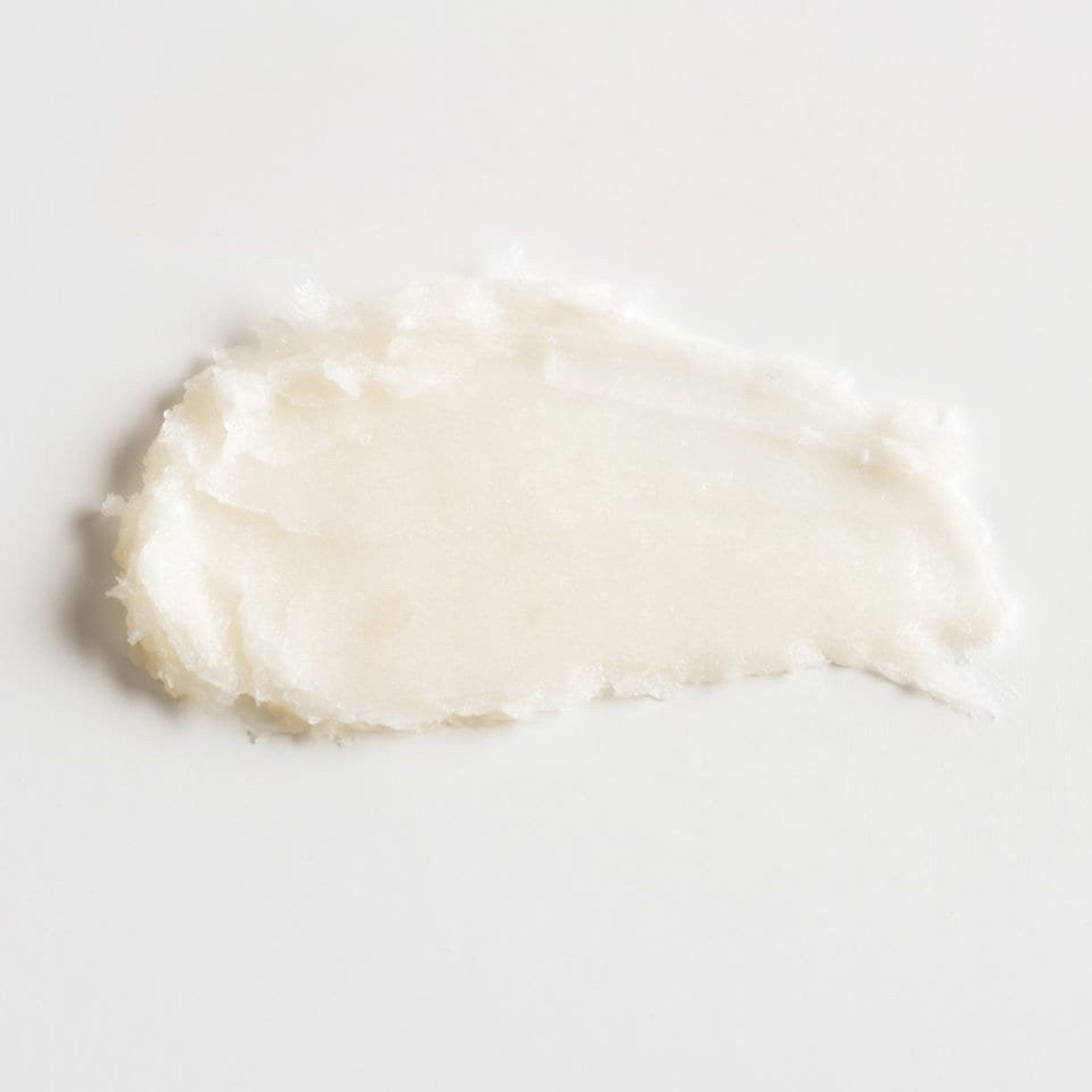 Close-up of vegan face cream with smooth texture in a minimalist white jar, showcasing plant-based formula