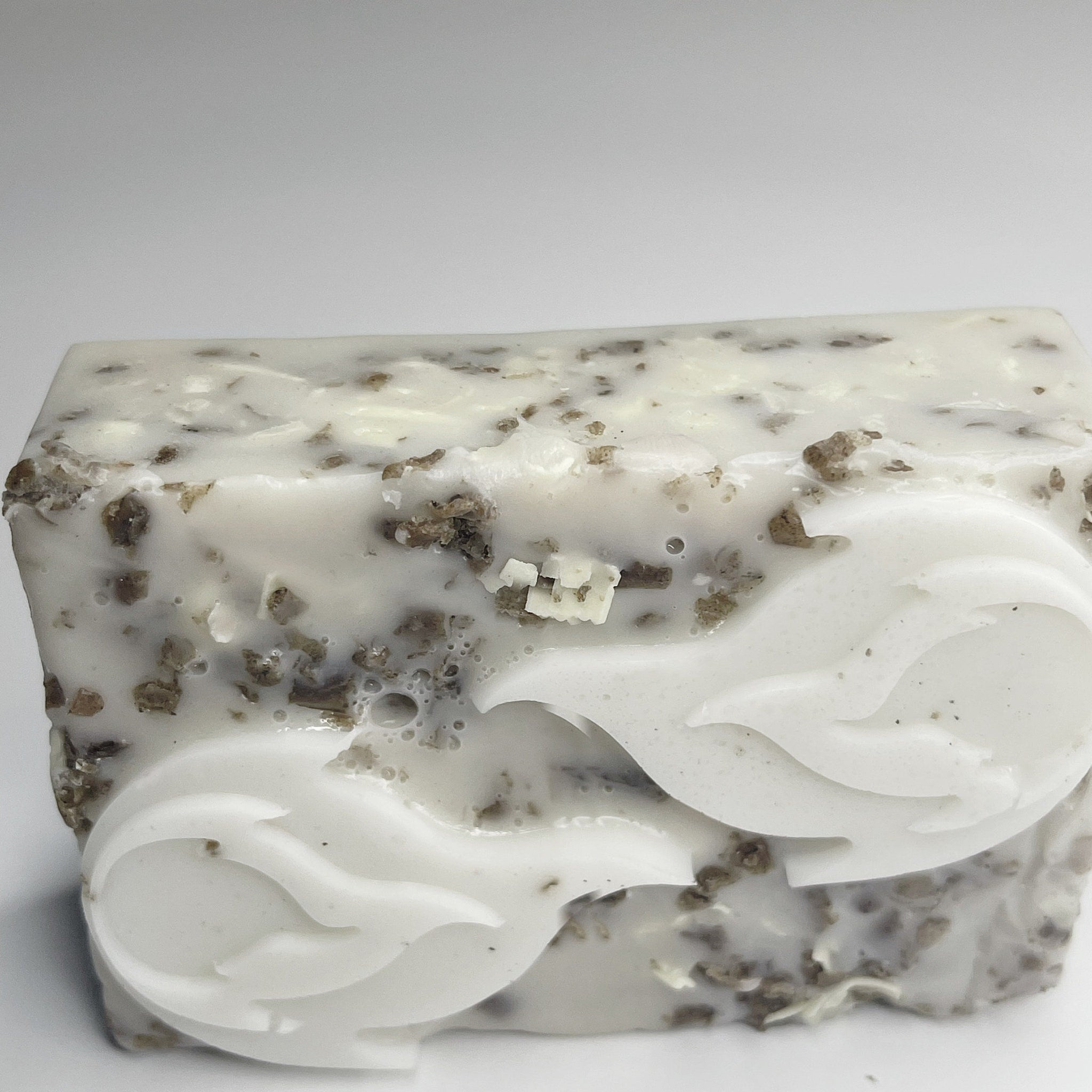 Soap bar with white and brown speckled pattern, carved floral design for bathing