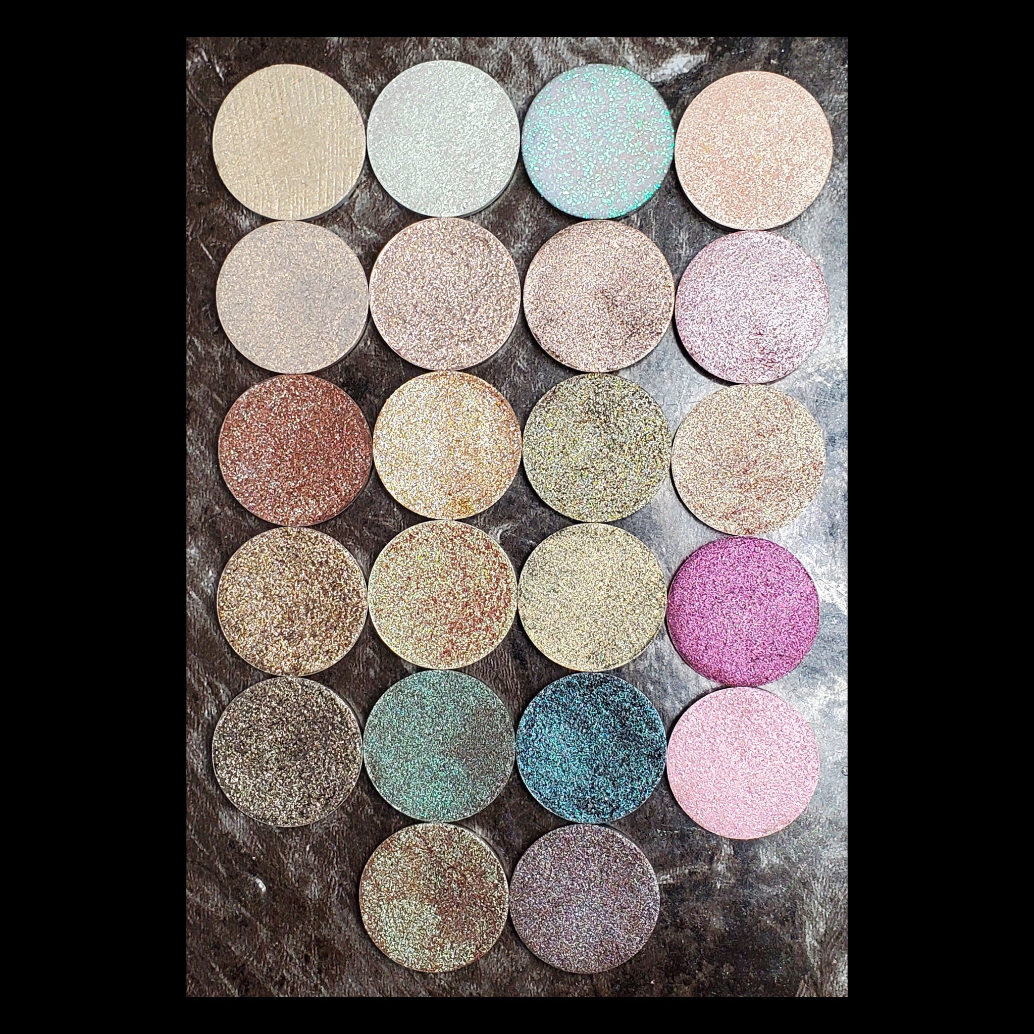 Circular magnetic eyeshadow refills in duochrome shades with metallic finish, arranged in palette.