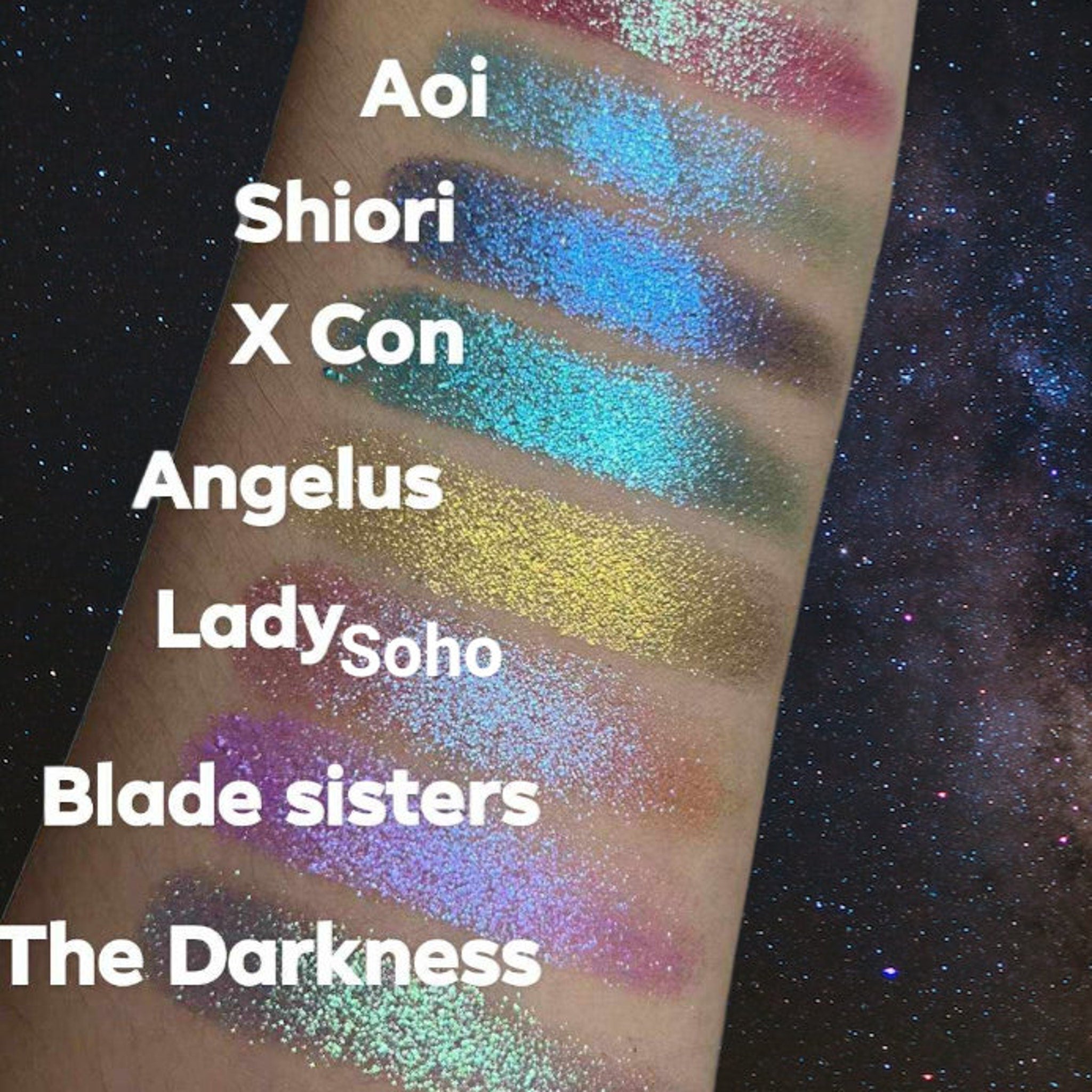 Glitter eyeshadow swatches in various colors, including blue, green, and purple, on arm with text labels