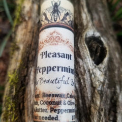 Lip balm tube with white and brown label, Pleasant Peppermint text, and bee illustration