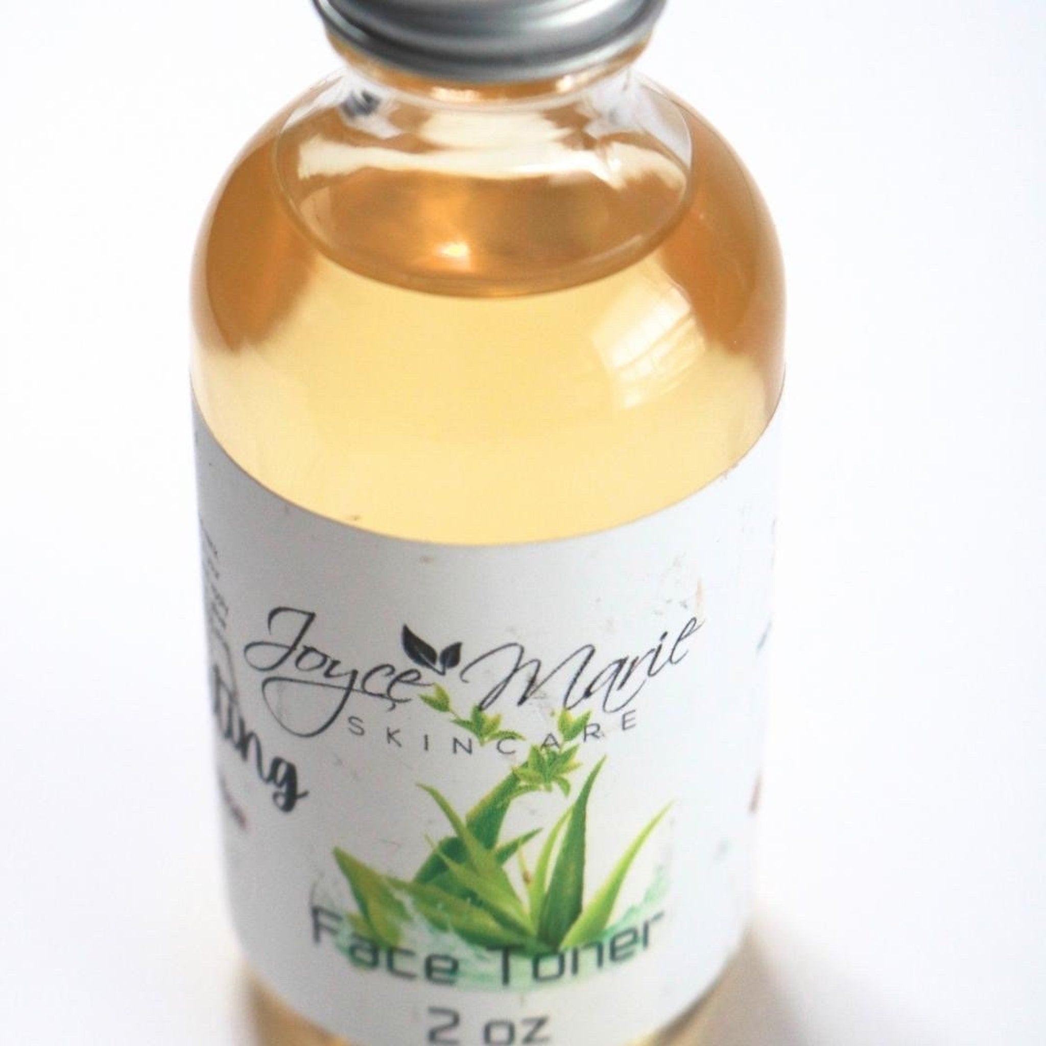 Face toner in glass bottle with yellow liquid, white label, and Joyce Marie Skincare text