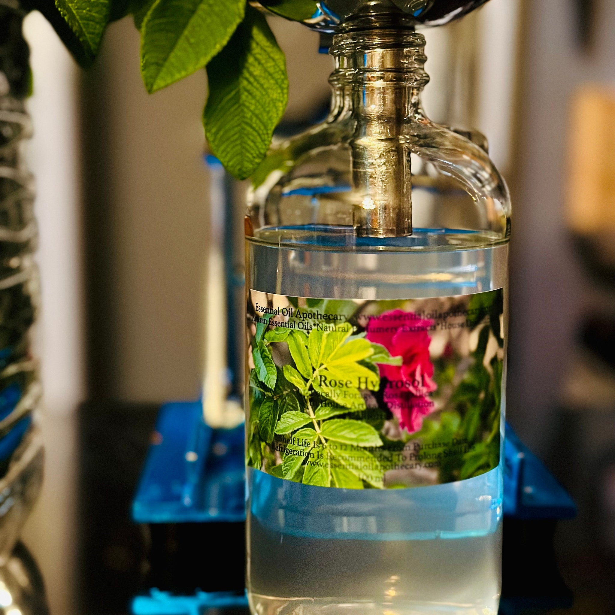 Essential oil bottle with clear glass, water, and label with text and rose image
