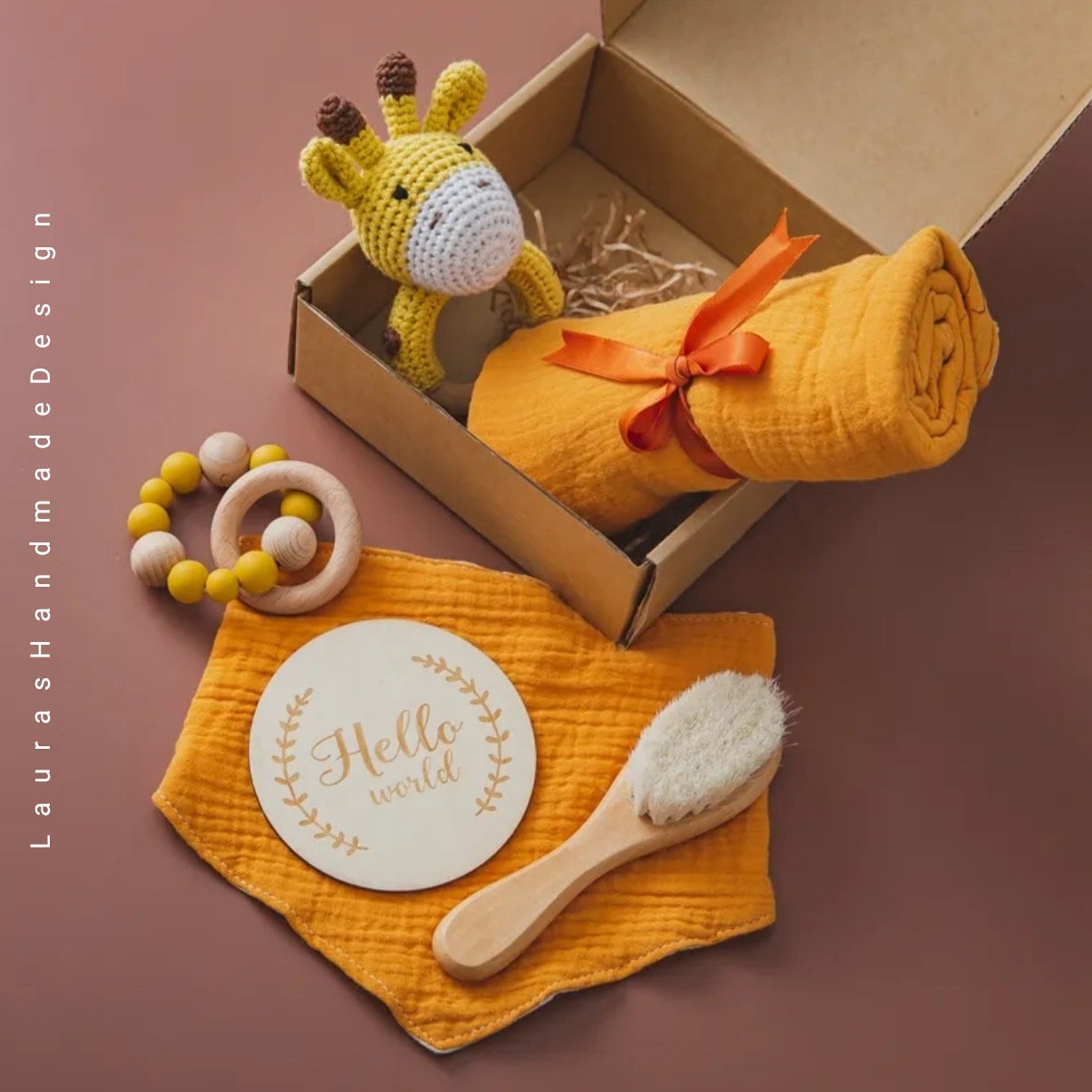 Baby gift set with yellow muslin, wooden teether, and crochet giraffe toy in a box
