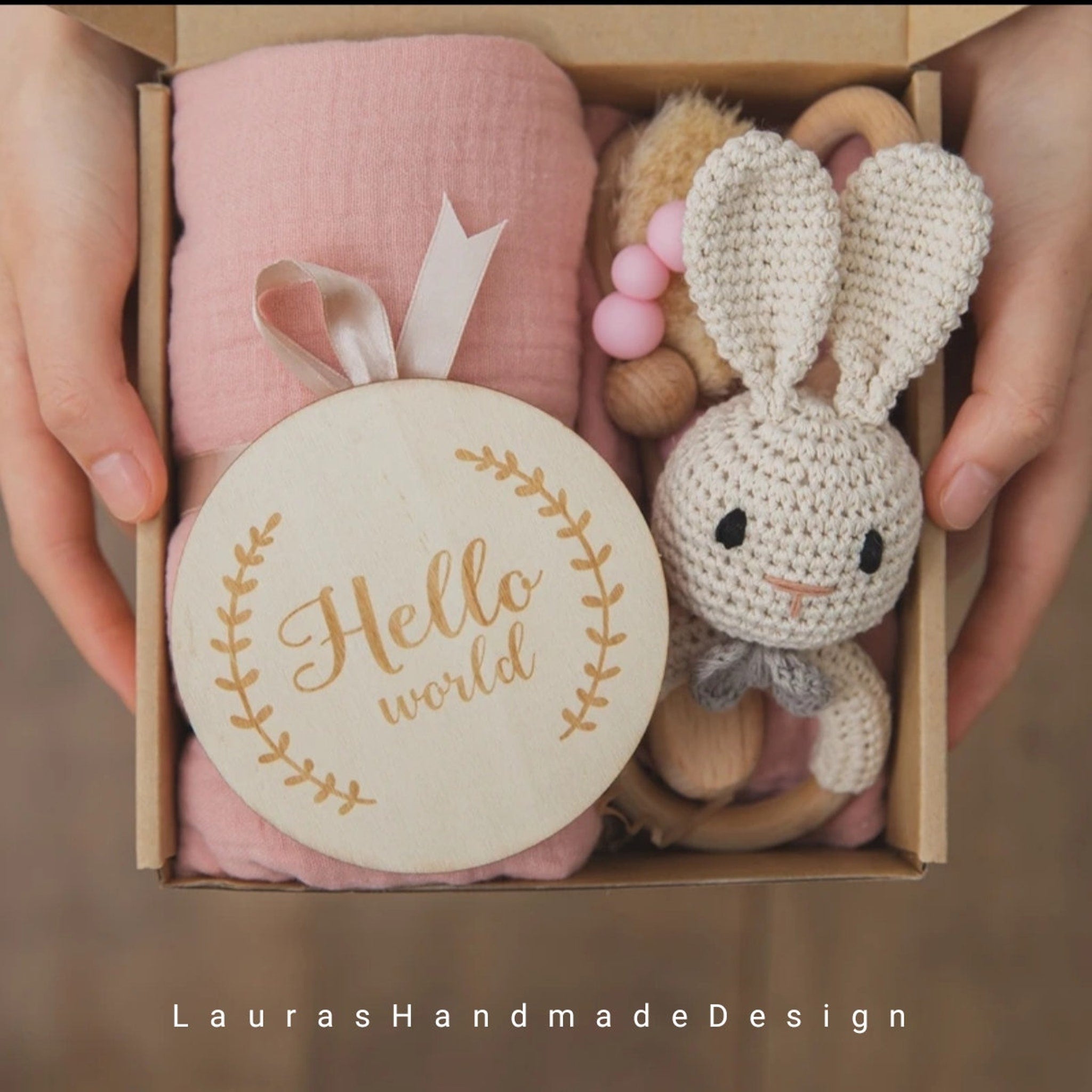 Baby gift set with pink blanket, crochet bunny, and wooden "Hello world" sign
