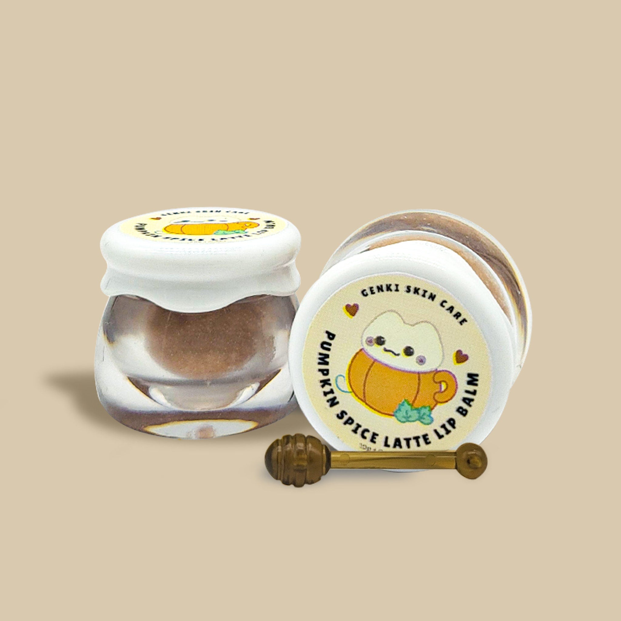 Lip balm jars with white lids, brown balm, and Genki Skincare label with pumpkin graphic