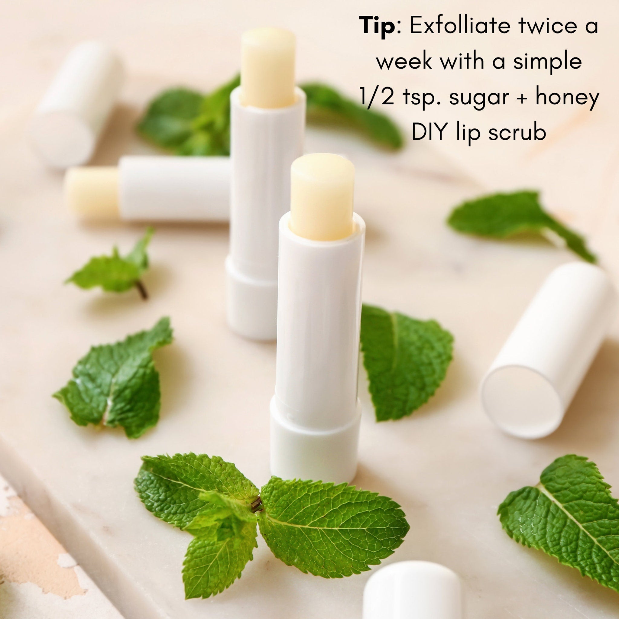 Lip balm tubes, white plastic, light yellow balm, with green mint leaves on surface