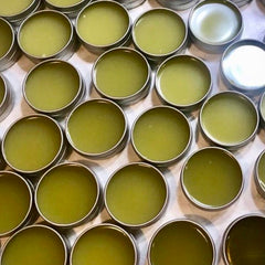 Balm tins with olive green color and silver metal containers, arranged in a grid pattern