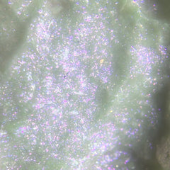 Close-up of sparkling blue iridescent liquid eyeshadow with frosted gel finish in sleek tube