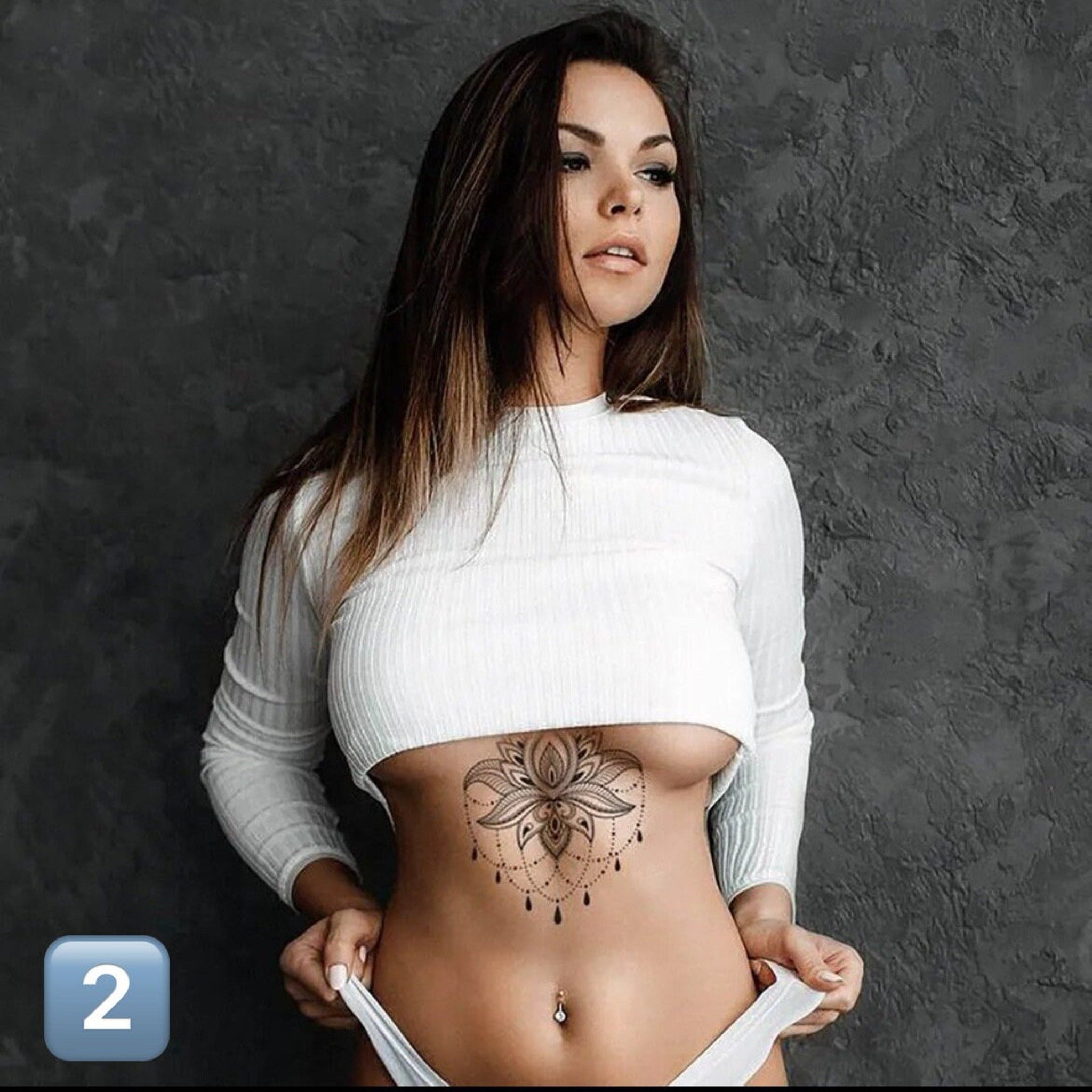 Close-up of delicate underboob tattoo design with fine line details on skin, showcasing temporary cosmetic application