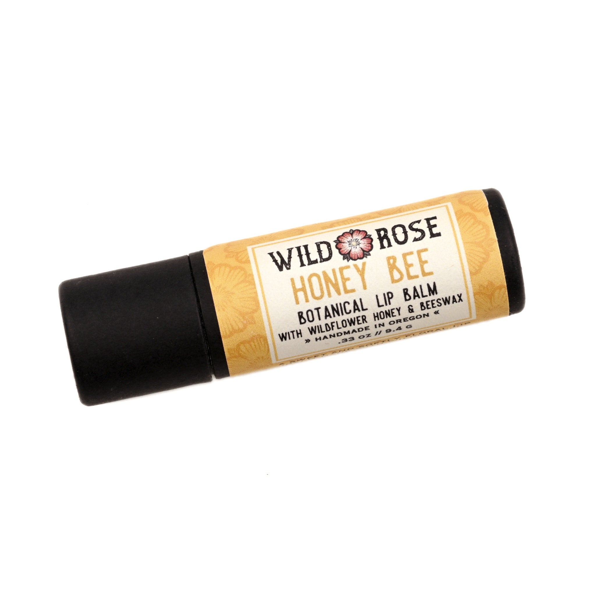 Lip balm tube with black and tan packaging, Wild Rose Honey Bee text visible
