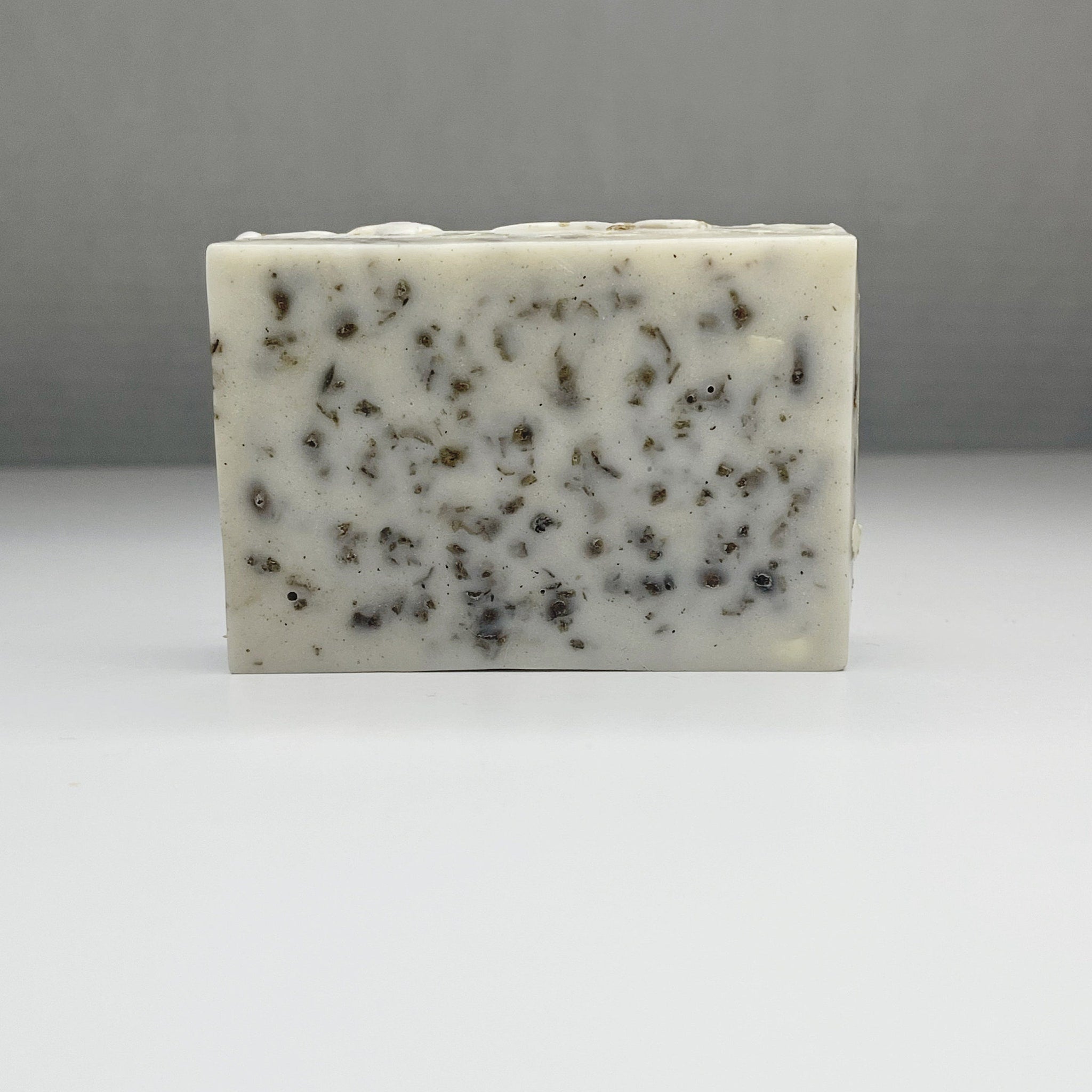 Soap bar with white and brown speckled pattern, square shape for washing