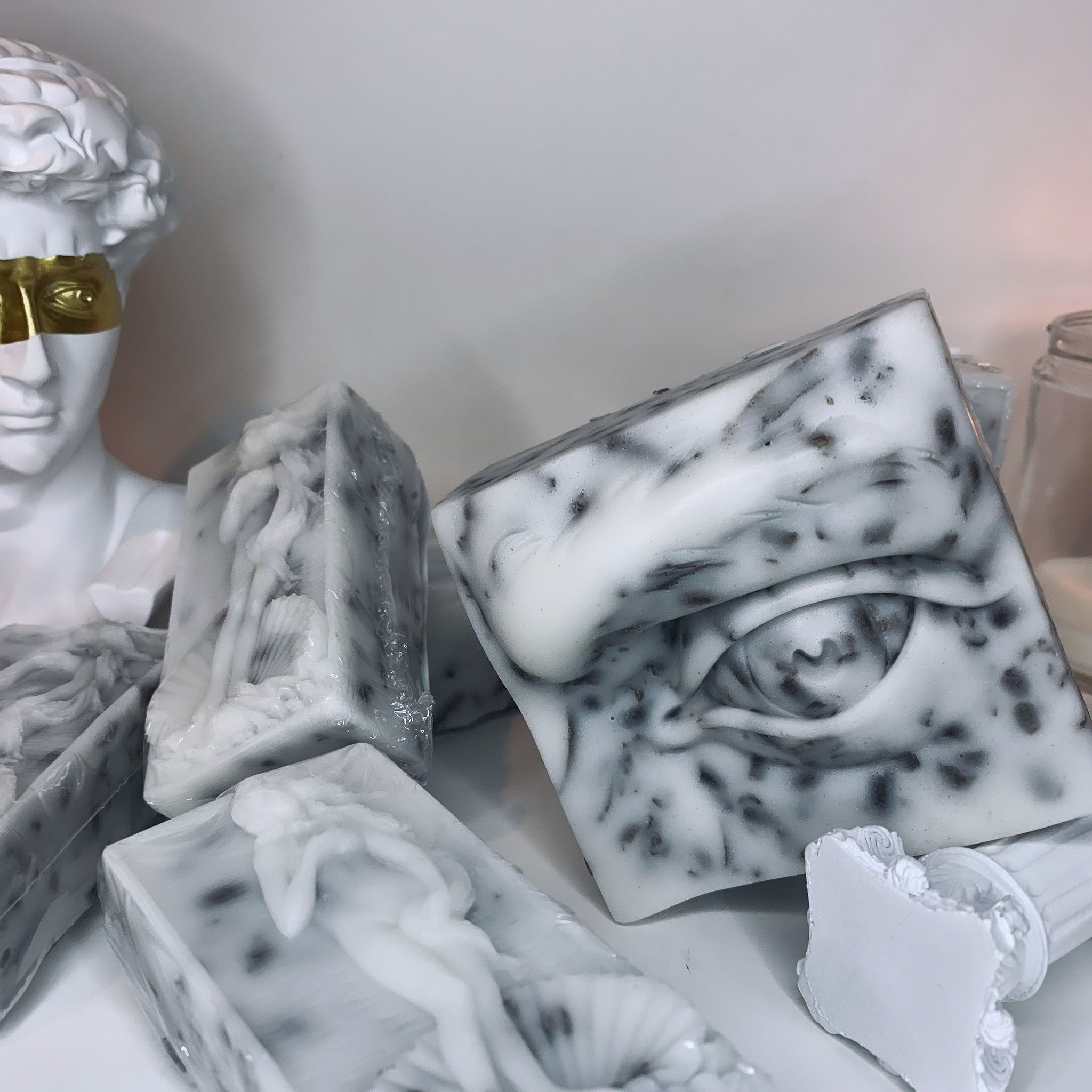 Sculptural soap bars in white and grey marble pattern with eye and figure designs