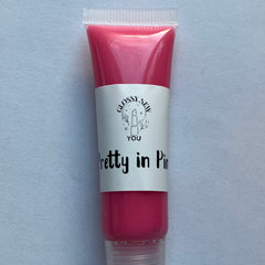 Lip gloss tube with pink gloss, white label, and "Pretty in Pink" text by Glossy New You