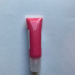 Lip gloss tube with pink liquid, clear applicator, and white label on a light blue background