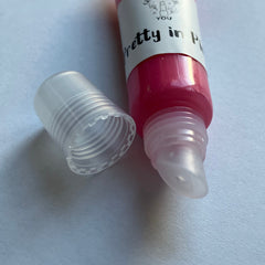 Lip gloss tube with pink gloss, clear plastic tube and cap, "Pretty in Pink" label