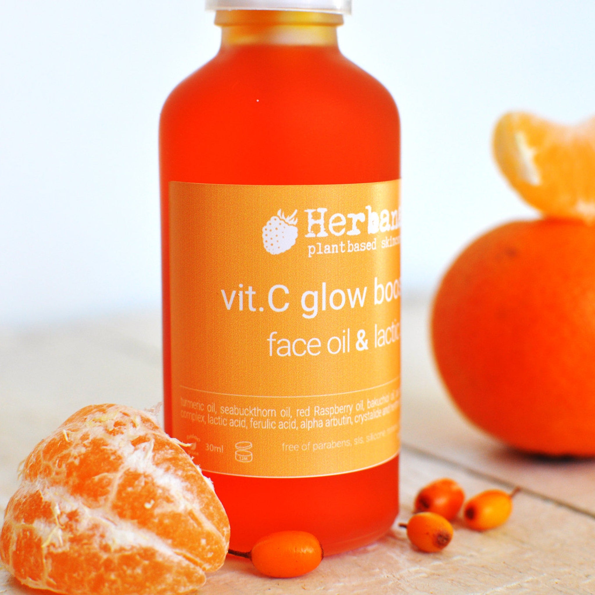 Close-up of golden vitamin C serum drops on fingertips with brightening effect demonstration