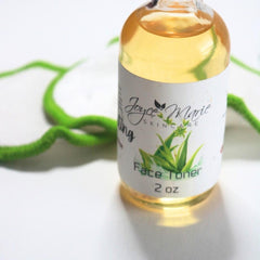 Face toner bottle with yellow liquid, white label, and green accents near green decor