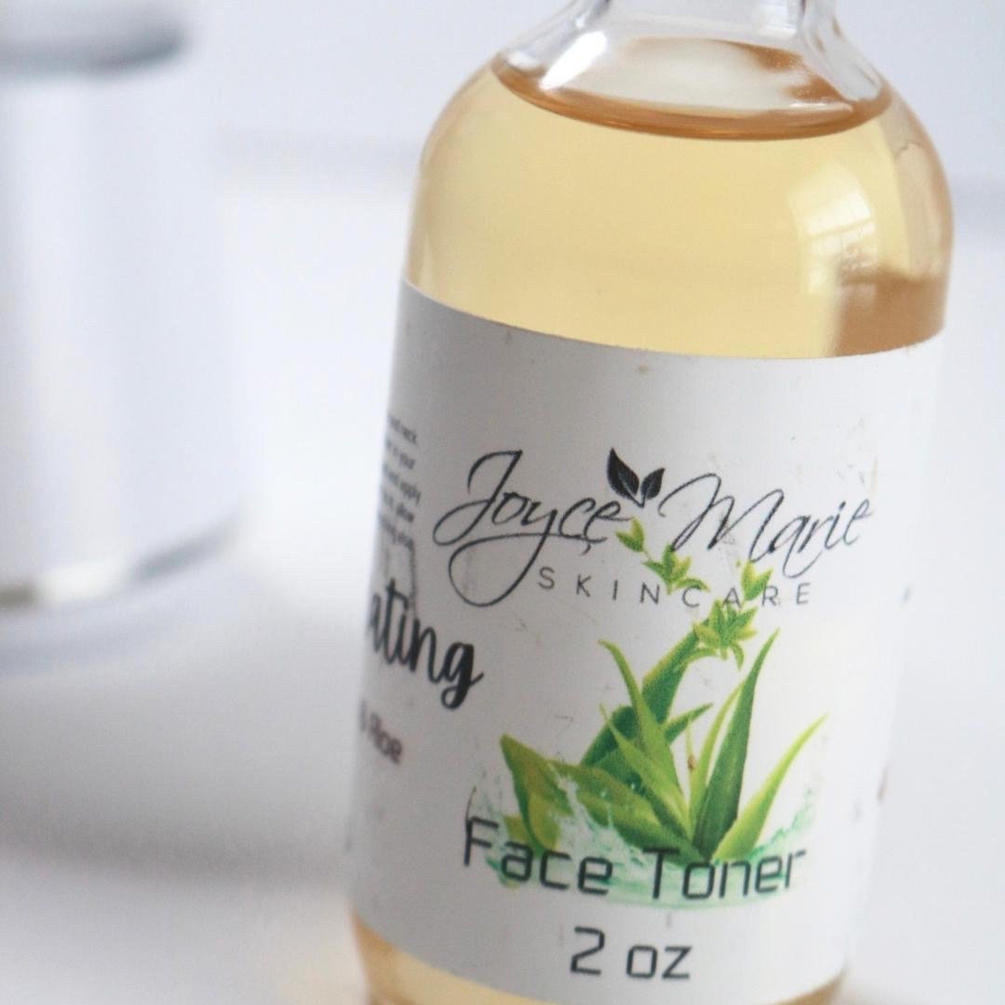 Face toner bottle with clear liquid, white label, and Joyce Marie Skincare branding visible
