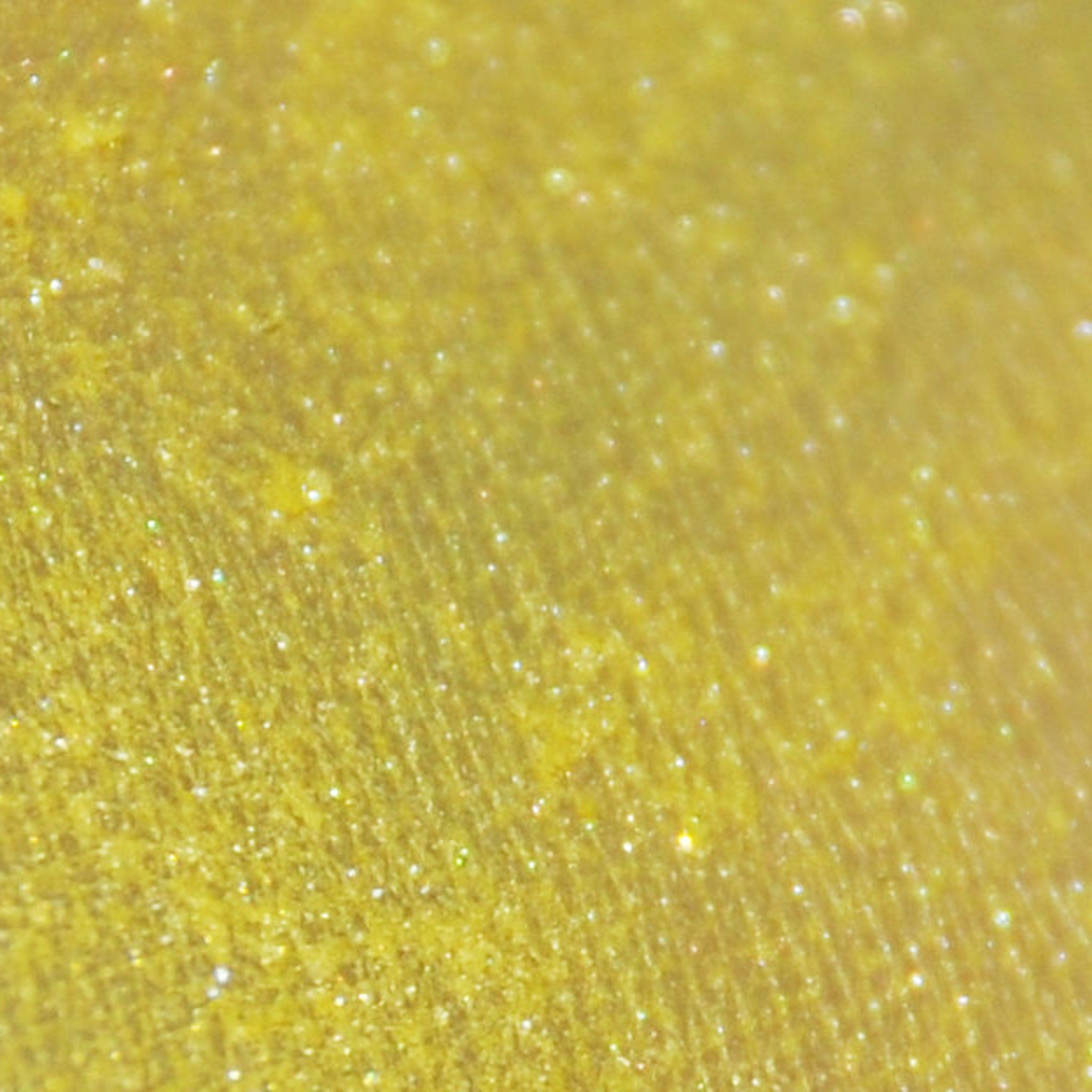 Side view of small glass jar with black sifter lid containing pigmented mineral eye shadow powder