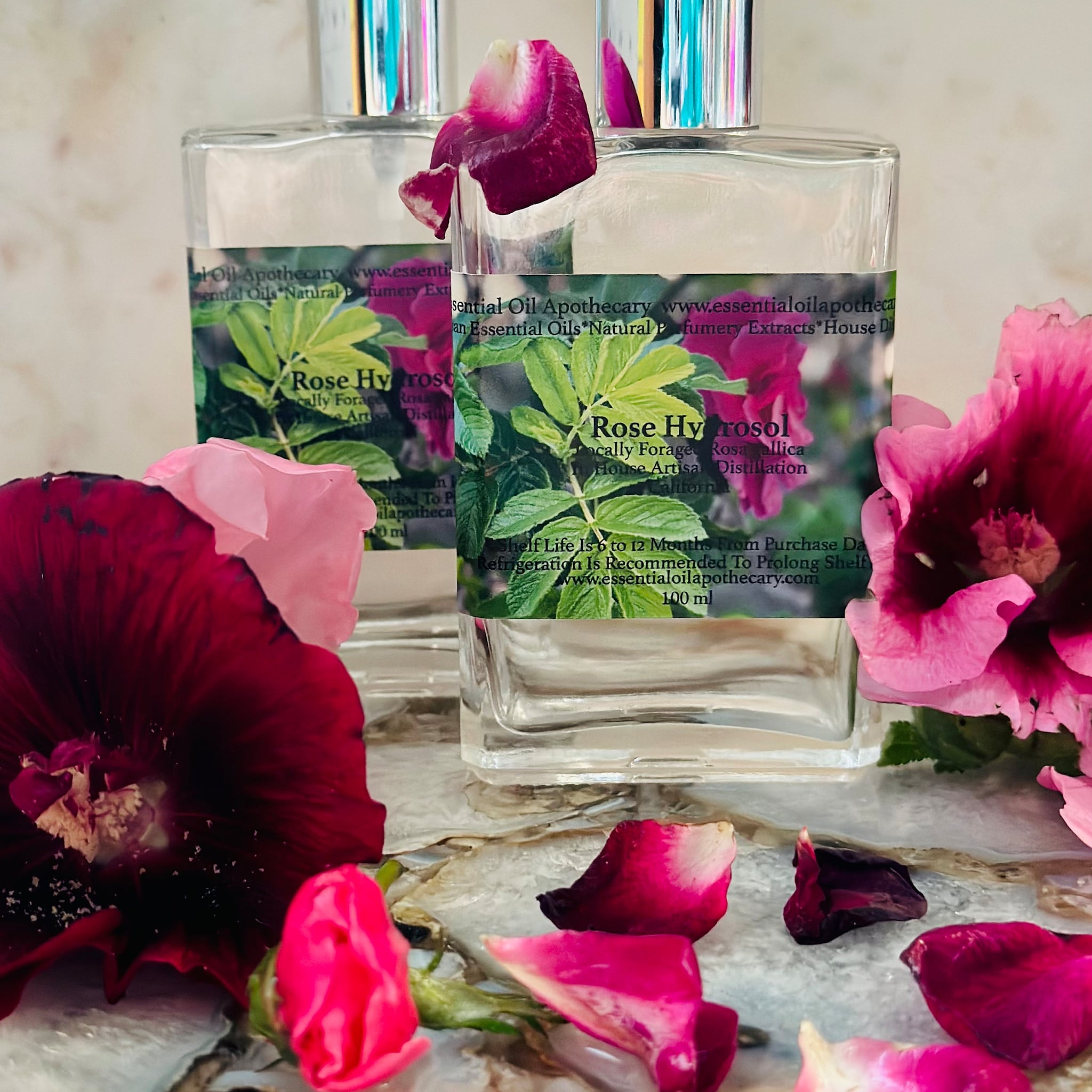 Essential oil bottles with clear glass, silver cap, and floral accents with "essentialoilapothecary" text visible