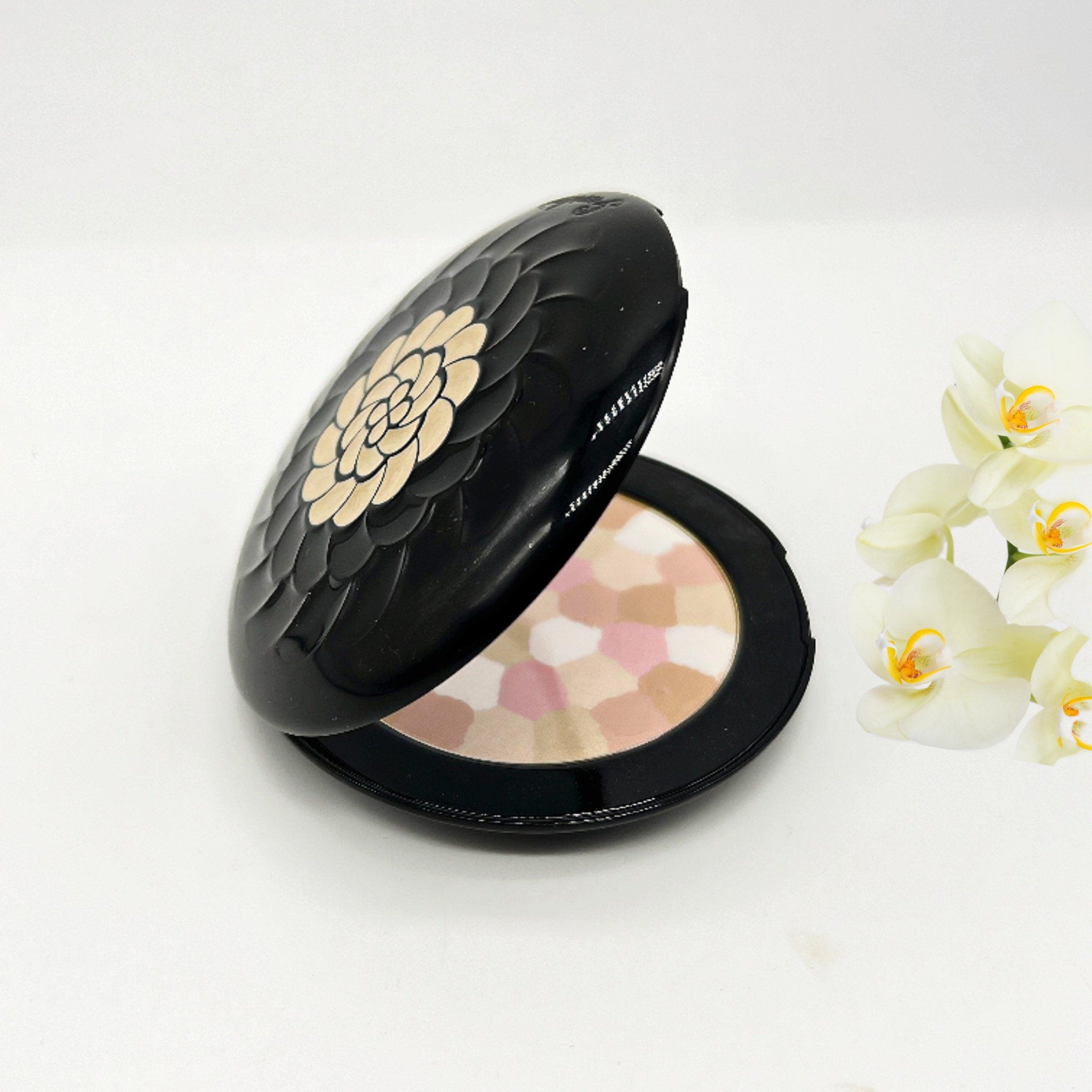 Powder compact with black case, floral design, and multi-color powder