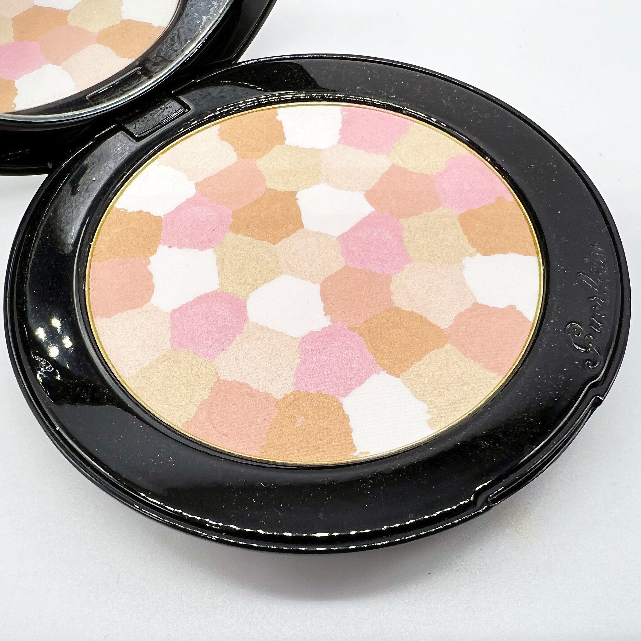 Powder compact with multi-color mosaic pattern and black case, Guerlain brand visible