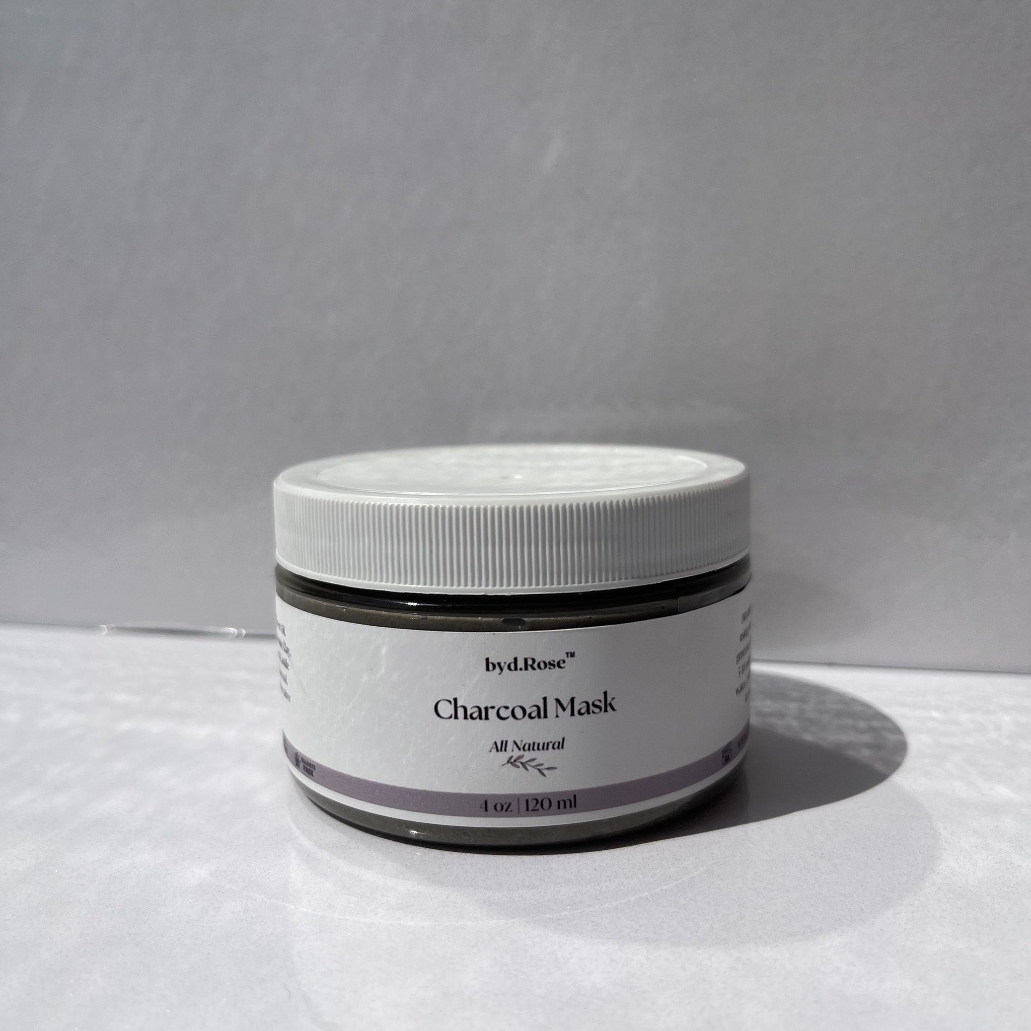 Charcoal mask jar, white plastic lid, gray label, byd.Rose branding, All Natural text