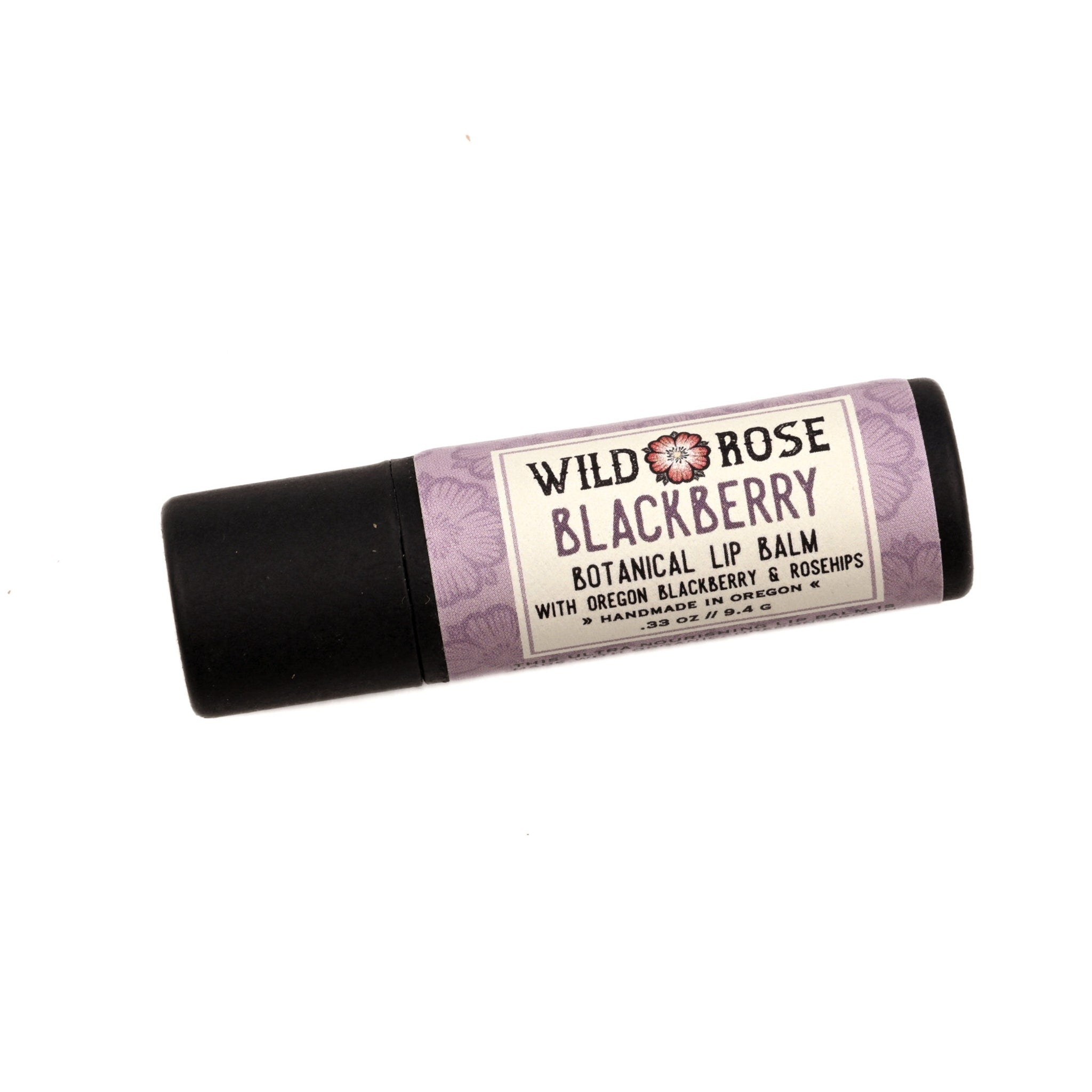 Lip balm tube with purple floral pattern, black cap, and Wild Rose Blackberry label