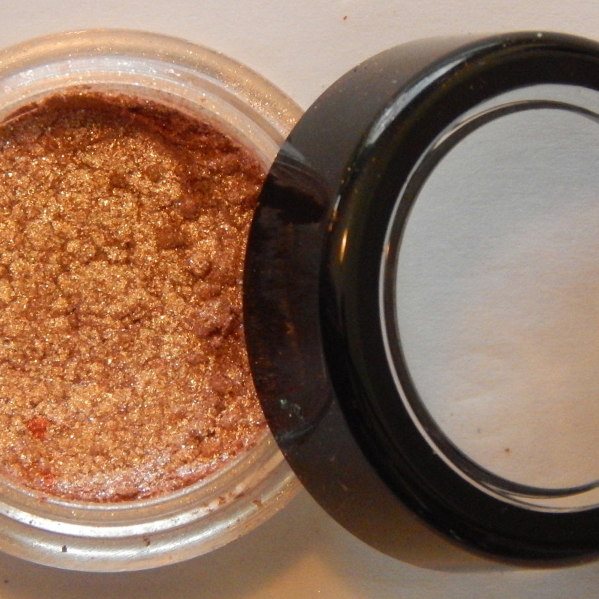 Close-up of Noisette mineral eye shadow showing soft matte texture and warm taupe-brown hue in compact case