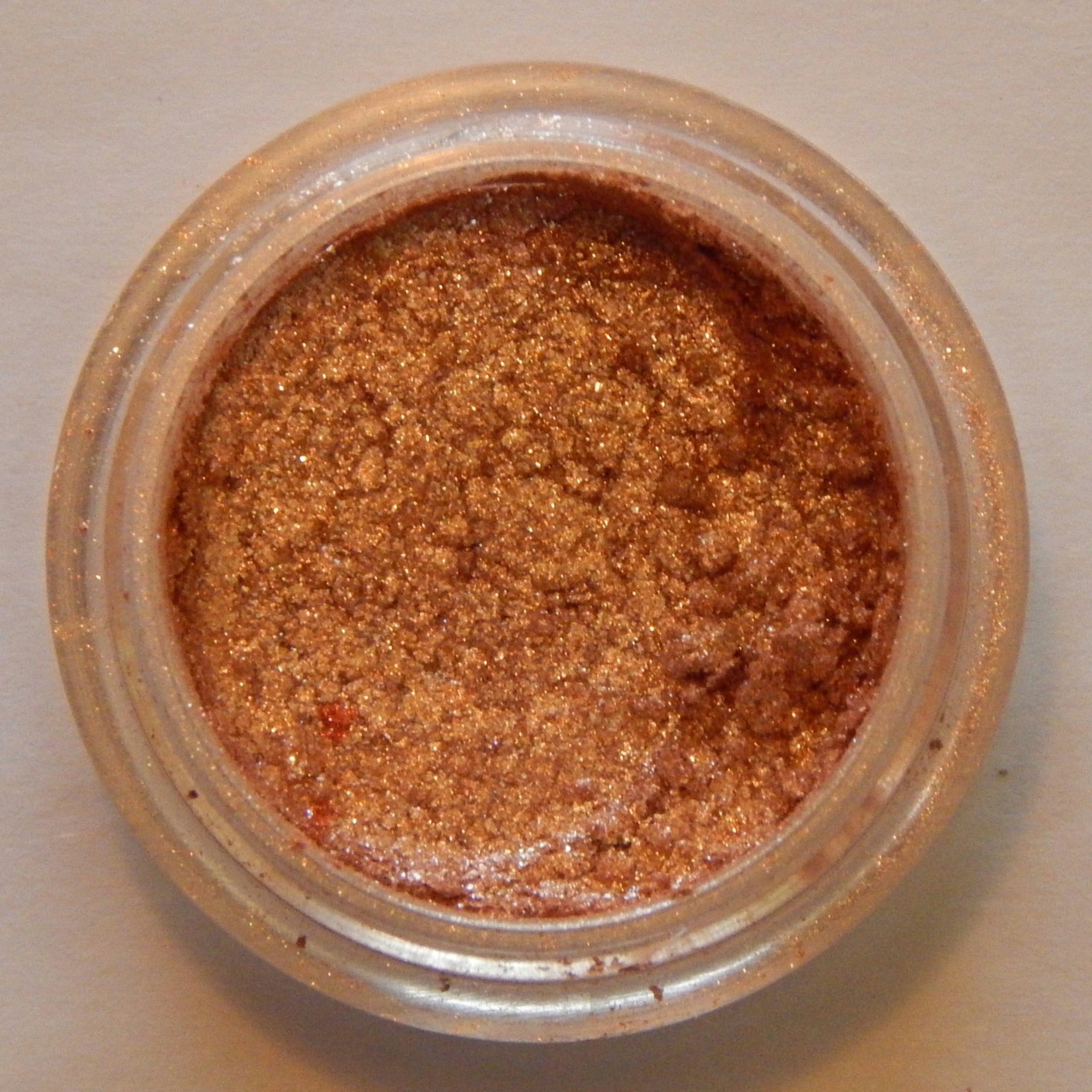 Side view of Noisette mineral eyeshadow compact showing matte taupe powder and sleek black case design