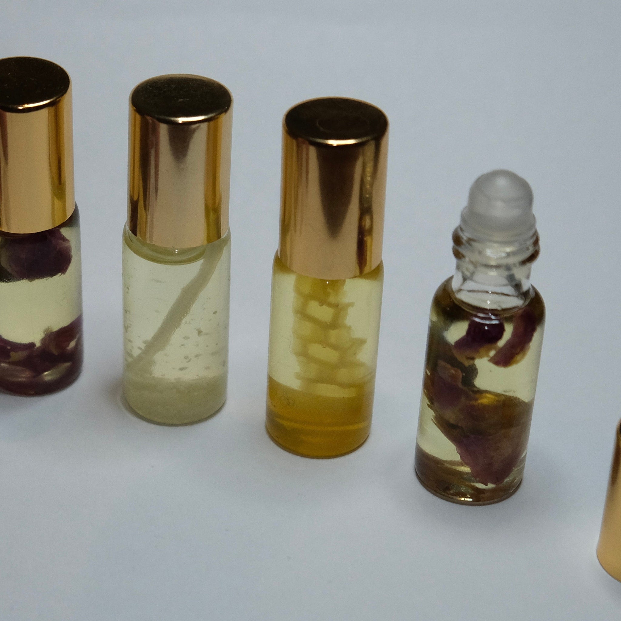 Perfume bottles with gold caps, clear glass, and floral inclusions