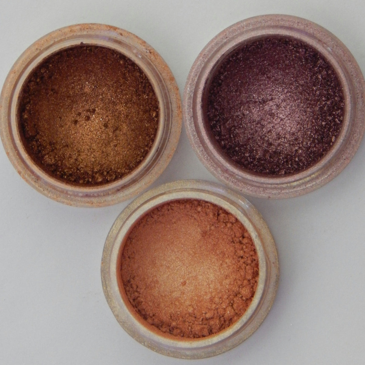 Three-pan mineral eyeshadow palette with warm desert tones in matte and shimmer finishes, displayed open