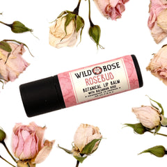 Lip balm with pink floral pattern, black tube, and ROSEBUD brand name, surrounded by dried roses