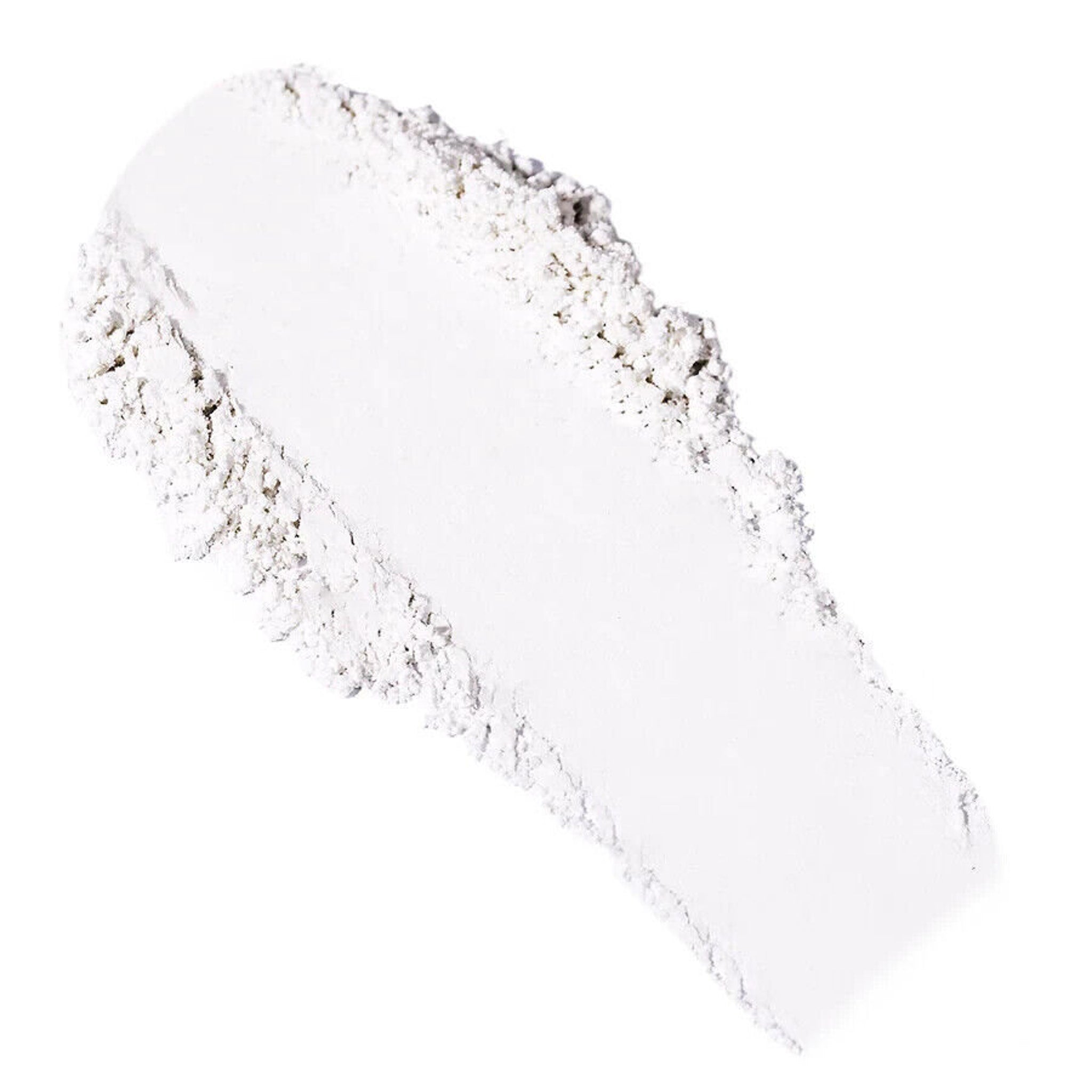 White powder swatch with textured edges and smooth center, isolated on white background