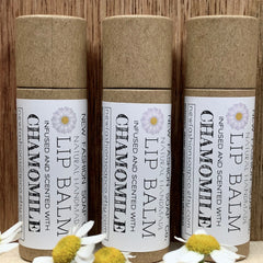 Lip balm tubes in brown cardboard, white label with chamomile design, "newfashionsoapco" text visible