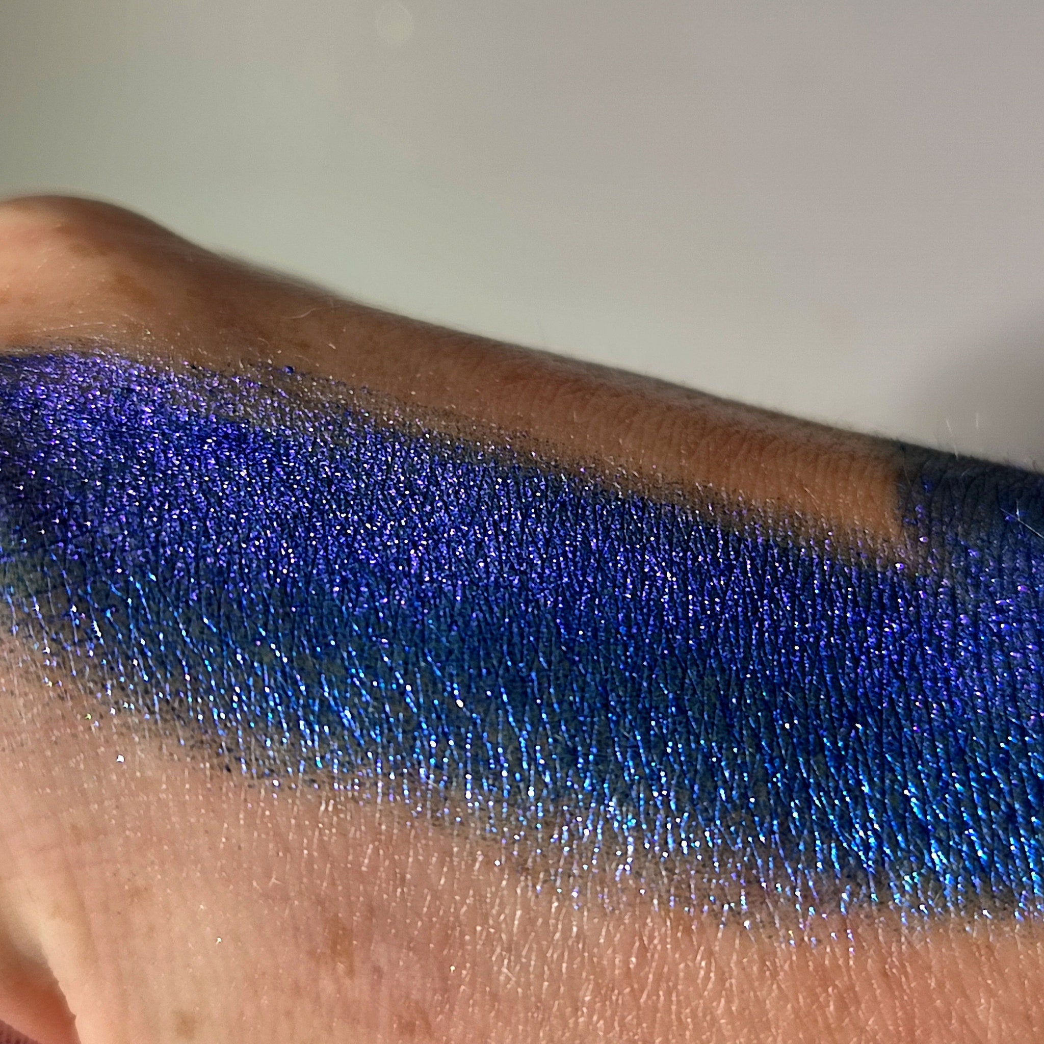 Eye shadow swatch, blue metallic shimmer, applied to skin