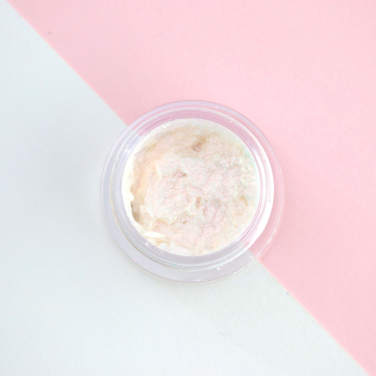 Sparkly pink iridescent liquid eyeshadow in a sleek tube with gold cap, shimmering under light