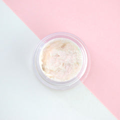 Sparkly pink iridescent liquid eyeshadow in a sleek tube with gold cap, shimmering under light