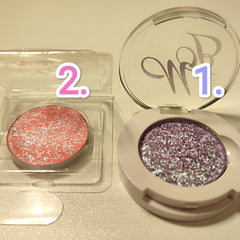 Eyeshadow compacts, pink and purple glitter, white and clear packaging, WB logo visible