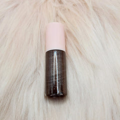Lip gloss, brown shimmer gloss with pink cap, on white fur background