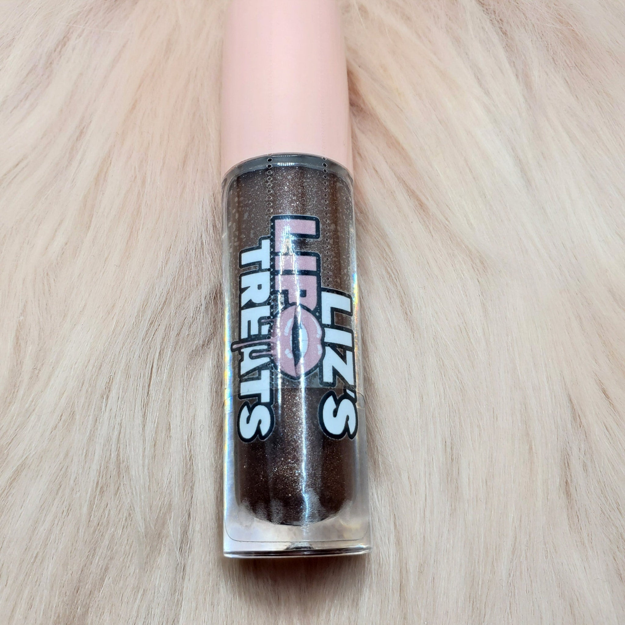 Lip gloss tube with brown glitter, pink cap, and "Liz's Treats" text on label