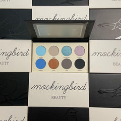 Eye shadow palette with eight colorful eyeshadows, Mockingbird Beauty brand visible