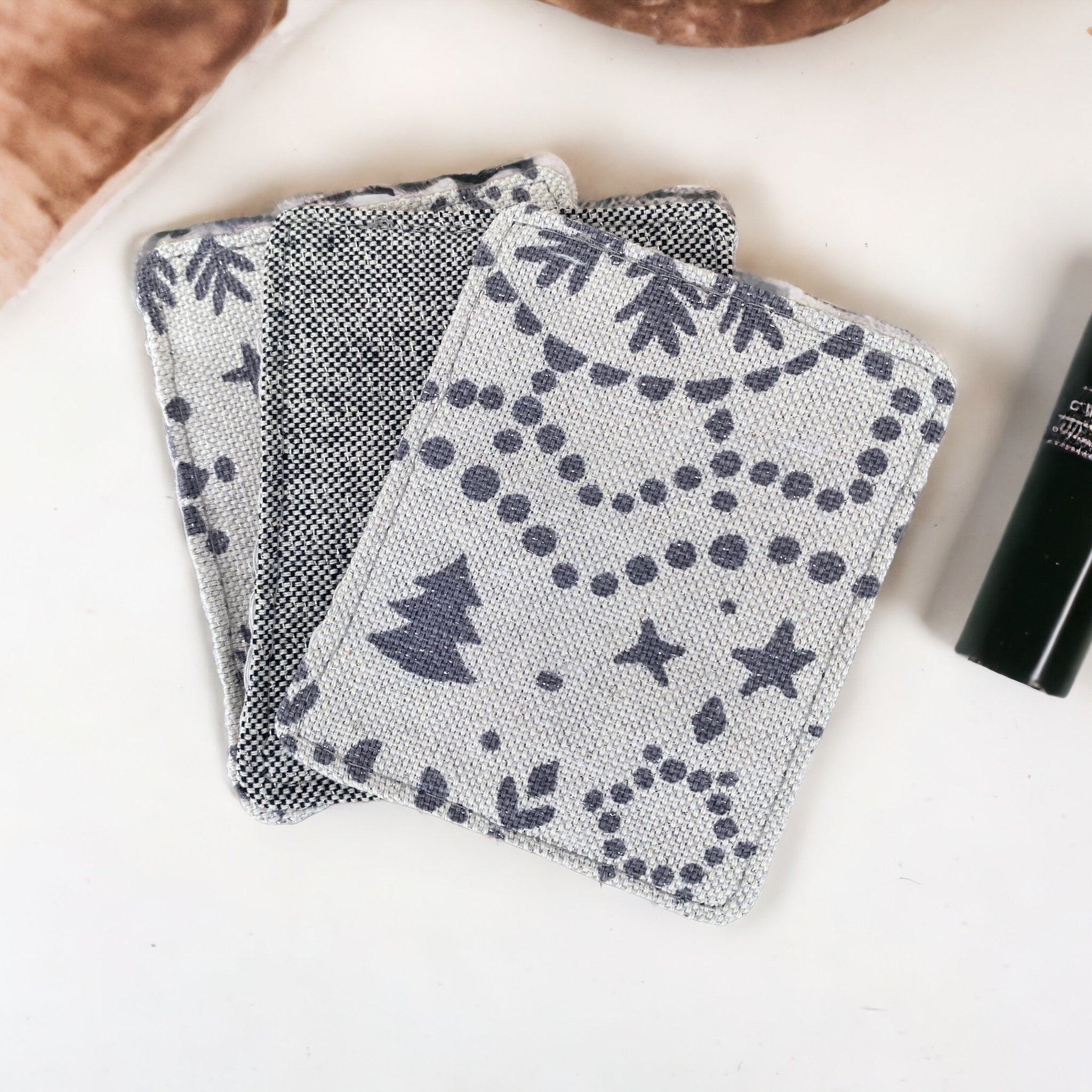 Reusable face pads, gray patterned fabric with tree and star designs, textured material